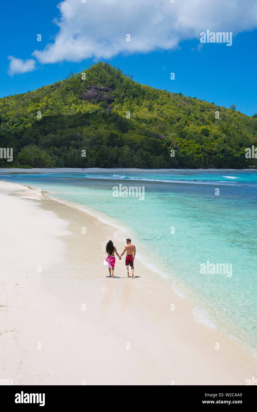 Couple walking along the beach, Mahe, Seychelleshands Stock Photo