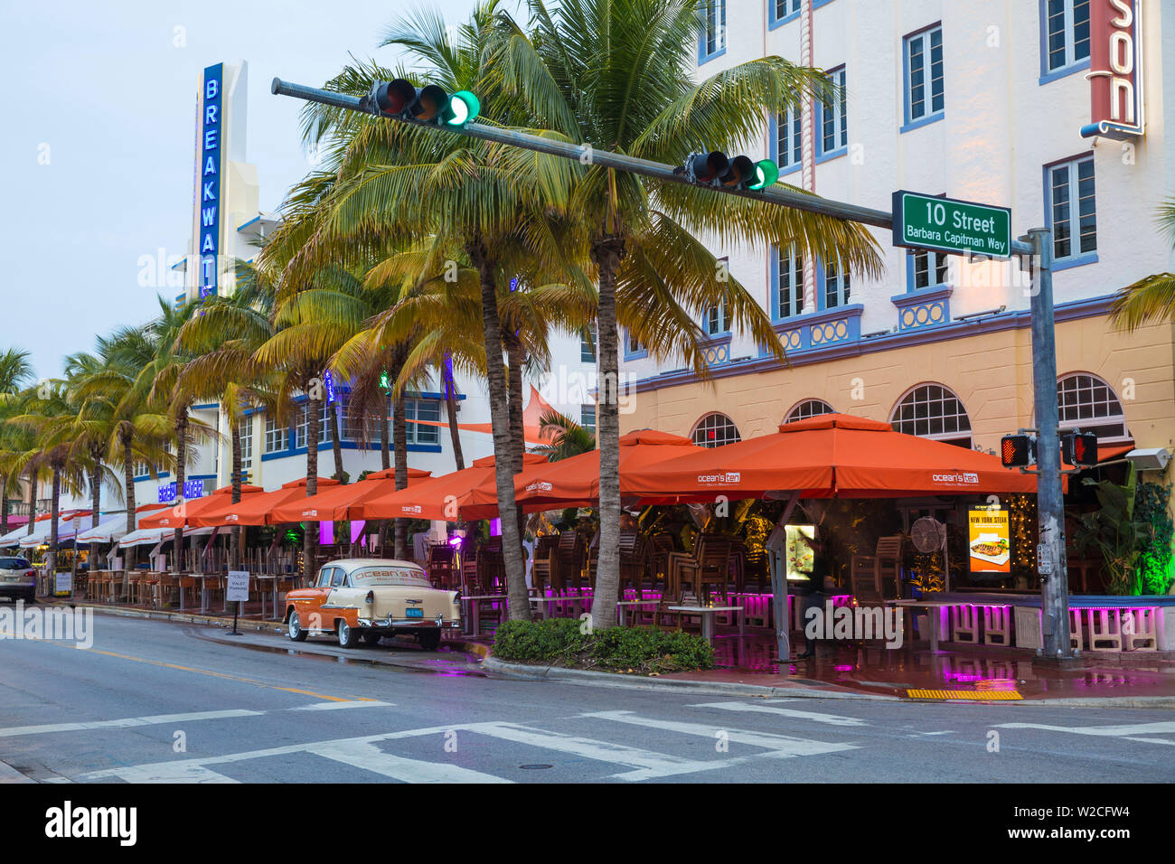 U.S.A, Miami, Miami Beach, South Beach,  Ocean Drive, Breakwater Hotel and Orange and white Chevrolet car parked outside Ocean's Ten restaurant Stock Photo
