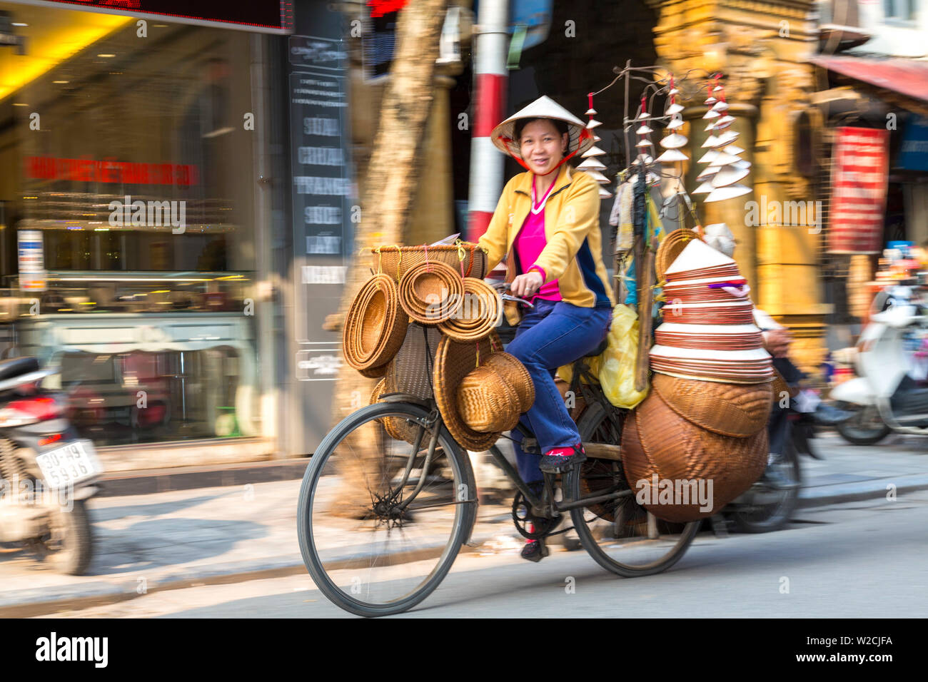 Basket & hat seller on bicycle, Hanoi, Vietnam Stock Photo