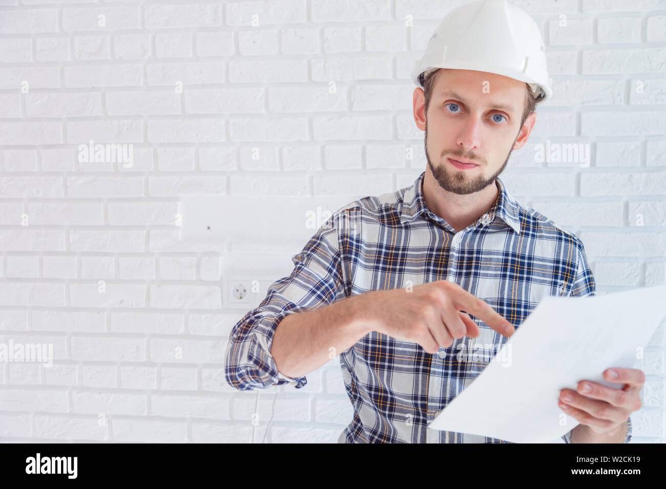 Engineer in hard hat pinting at important document Stock Photo Alamy