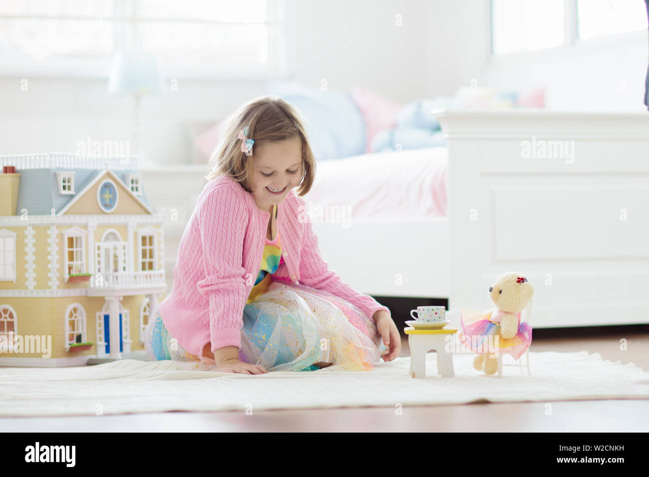 girl playing with dollhouse