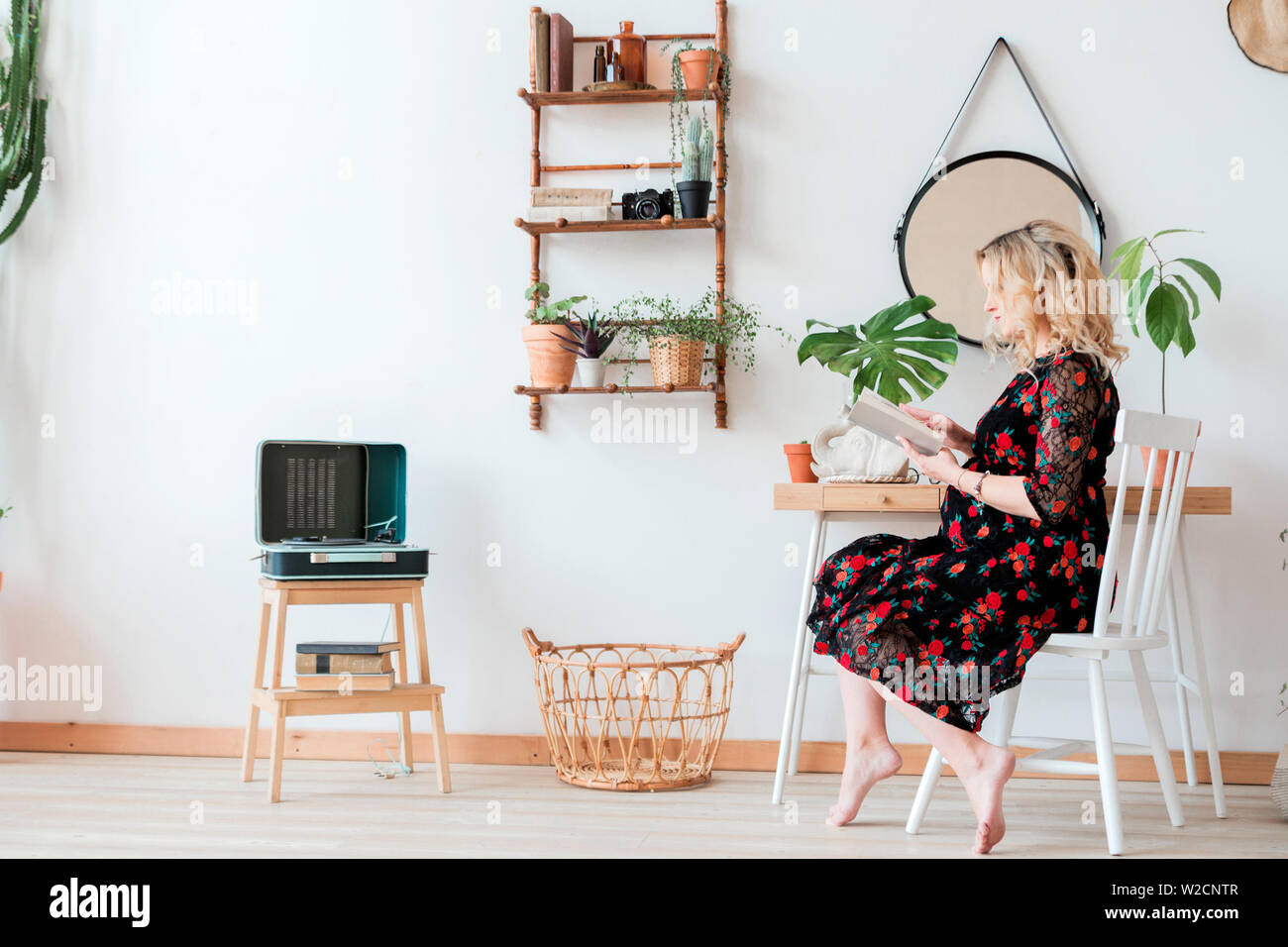 photo of pregnant woman in black dress sits and reads a book Stock Photo