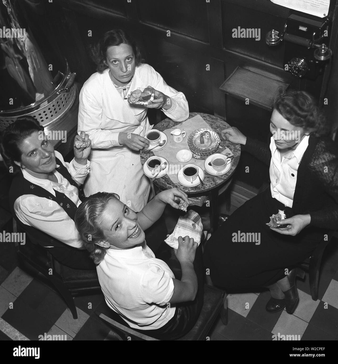 1940s Fika . Four young woman working at the cafe Röda rummet in Stockholm are sitting together and having a cup of coffee and tea.  Sweden. Photo Kristoffersson Ref 215-2. Sweden 1941 Stock Photo