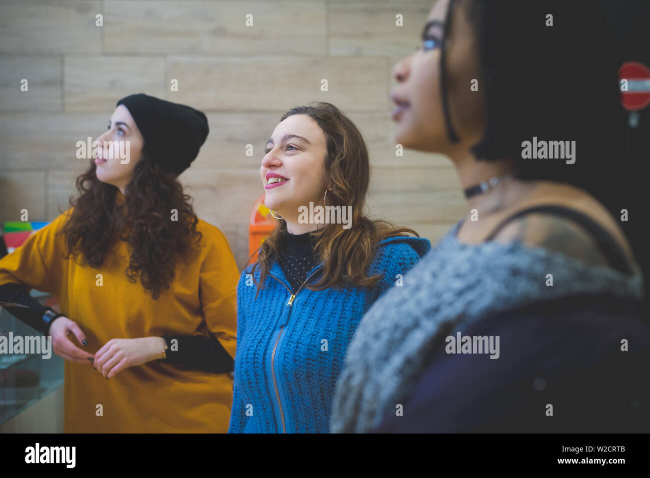 three young multiracial women looking ahead – imagination, togetherness, cheerful Stock Photo