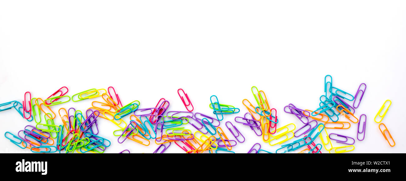 Panorama of colorful paper clips isolated on white background with copy space. Back to school web banner. Stock Photo