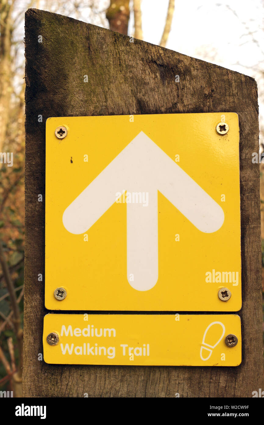 A Yellow Arrow Sign Indicating a Medium Difficulty Walking Trail Stock Photo
