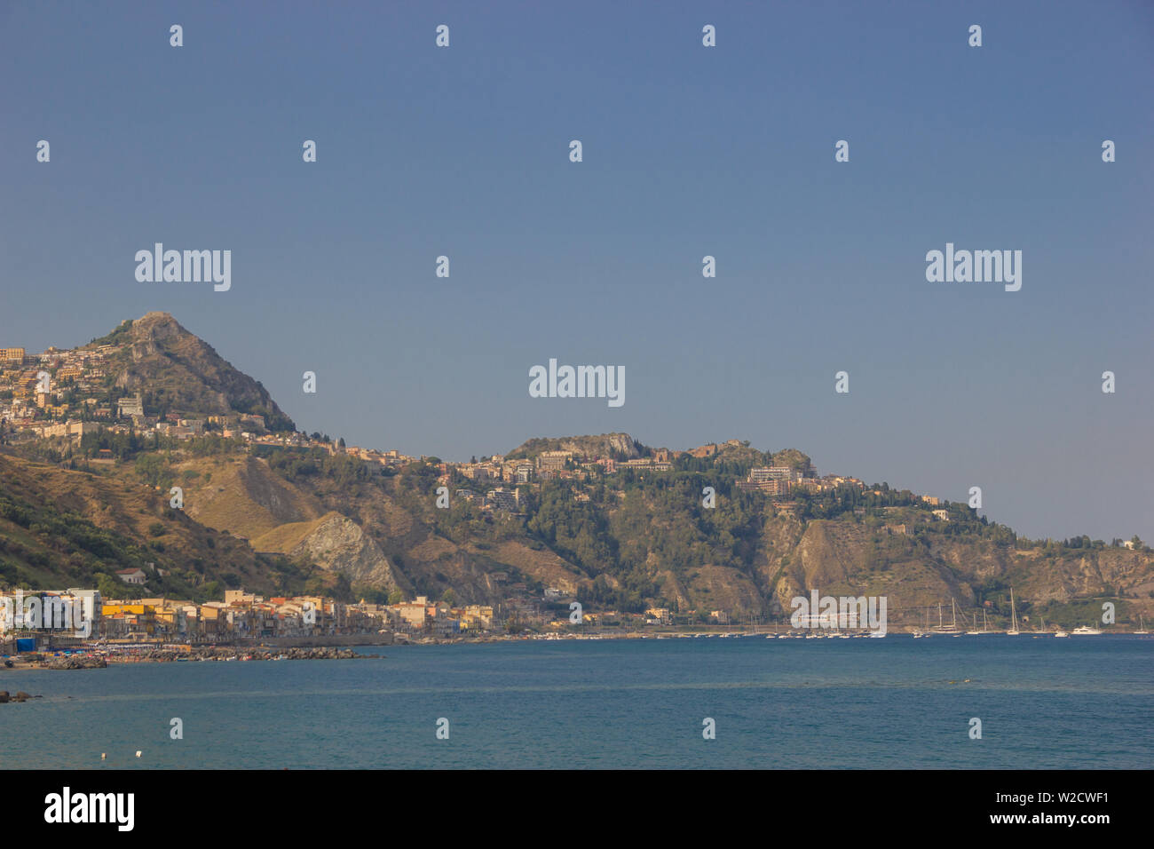 Giardini Naxos Sicily Italy 2019 close up view of the mountains and of famous Taormina on a beautiful blue sea Stock Photo