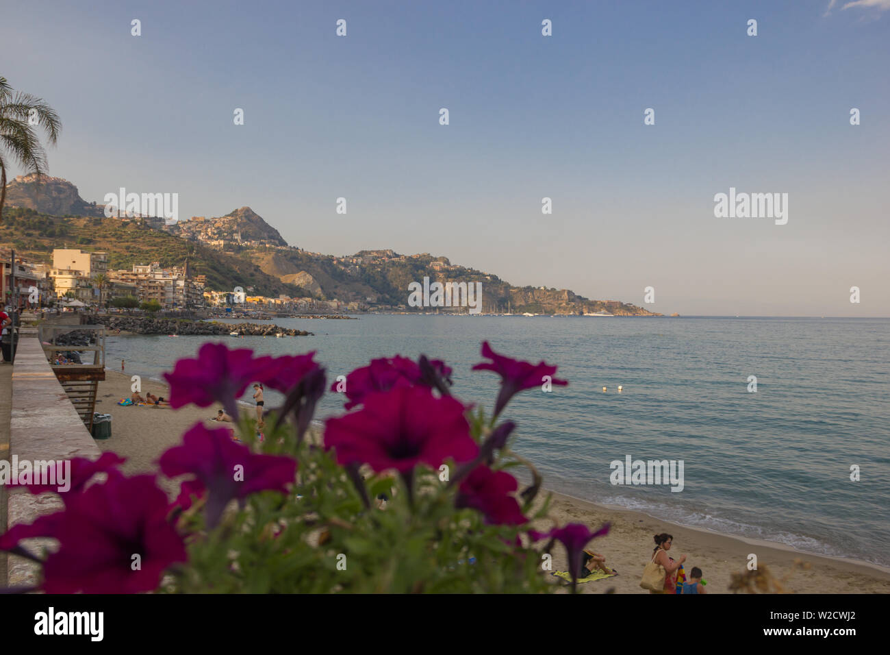 Giardini Naxos Sicily Italy 2019 beautiful landscape of the coastline in Summer from the main street with some close flowers, scenic seascape Stock Photo