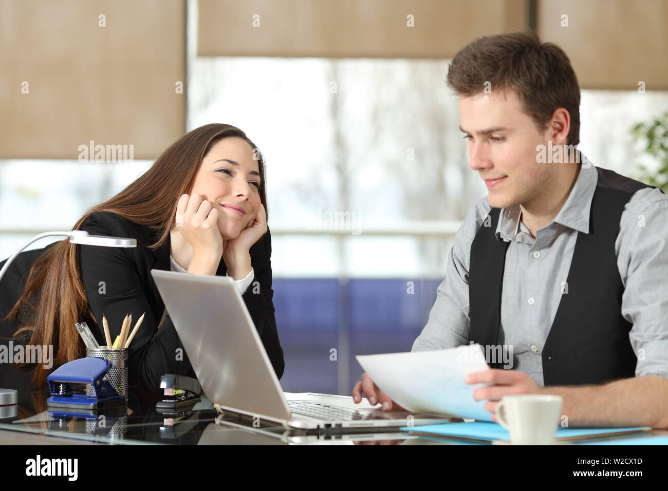 Candid young businesswoman falling in love with a colleague at office Stock Photo