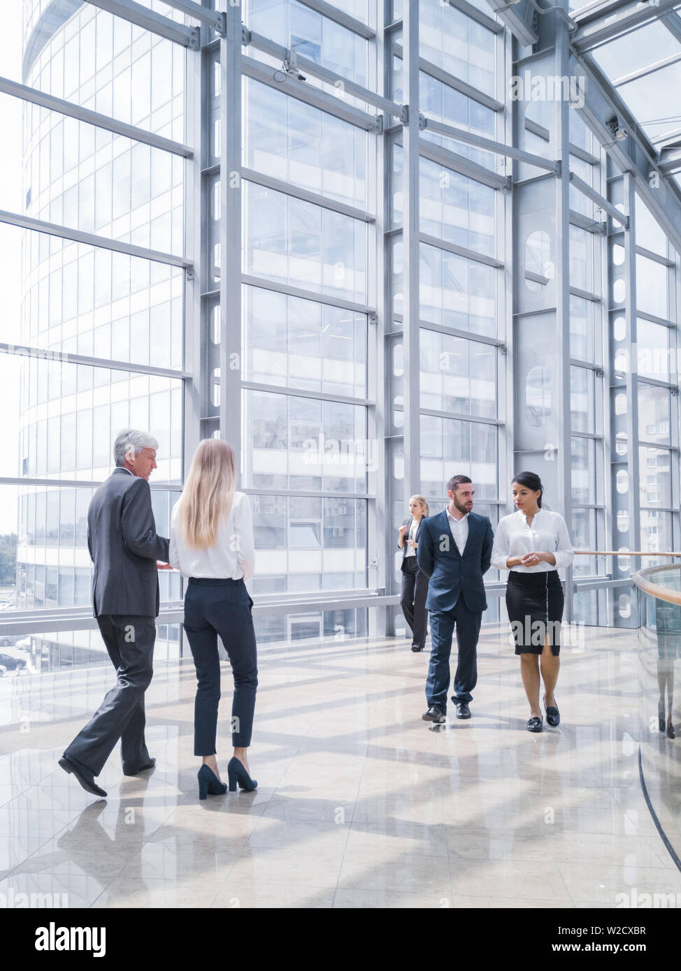 Business people walking in a modern hall of office building Stock Photo ...