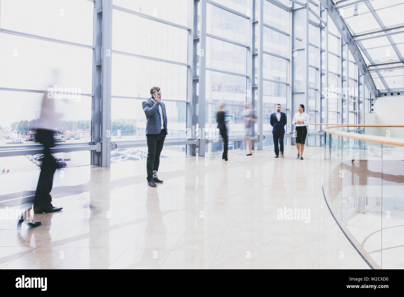 Business people walking in a modern hall of office building Stock Photo ...