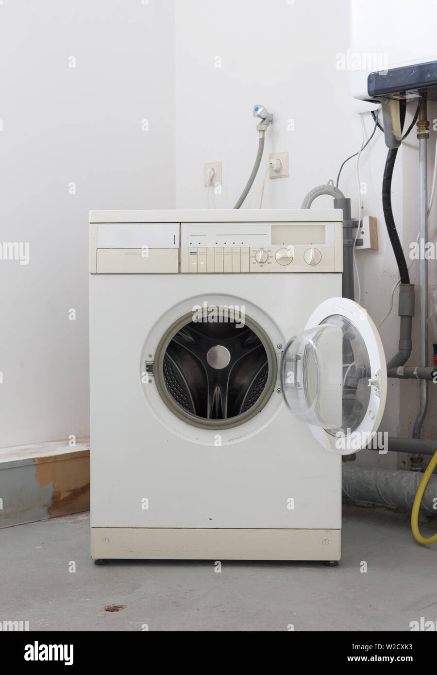 Old dirty washing machine on the attic, door open Stock Photo - Alamy