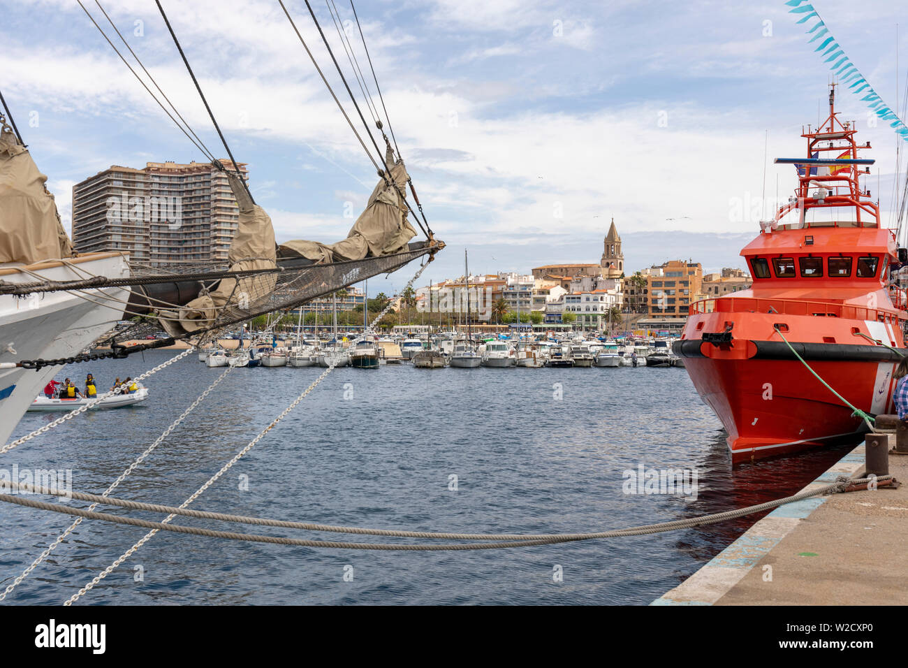 Marine Festival at Palamos  Harbour, Costa Brava, Spain, with a sailing ship bowsprit and deep sea rescue vessel in the foreground Stock Photo