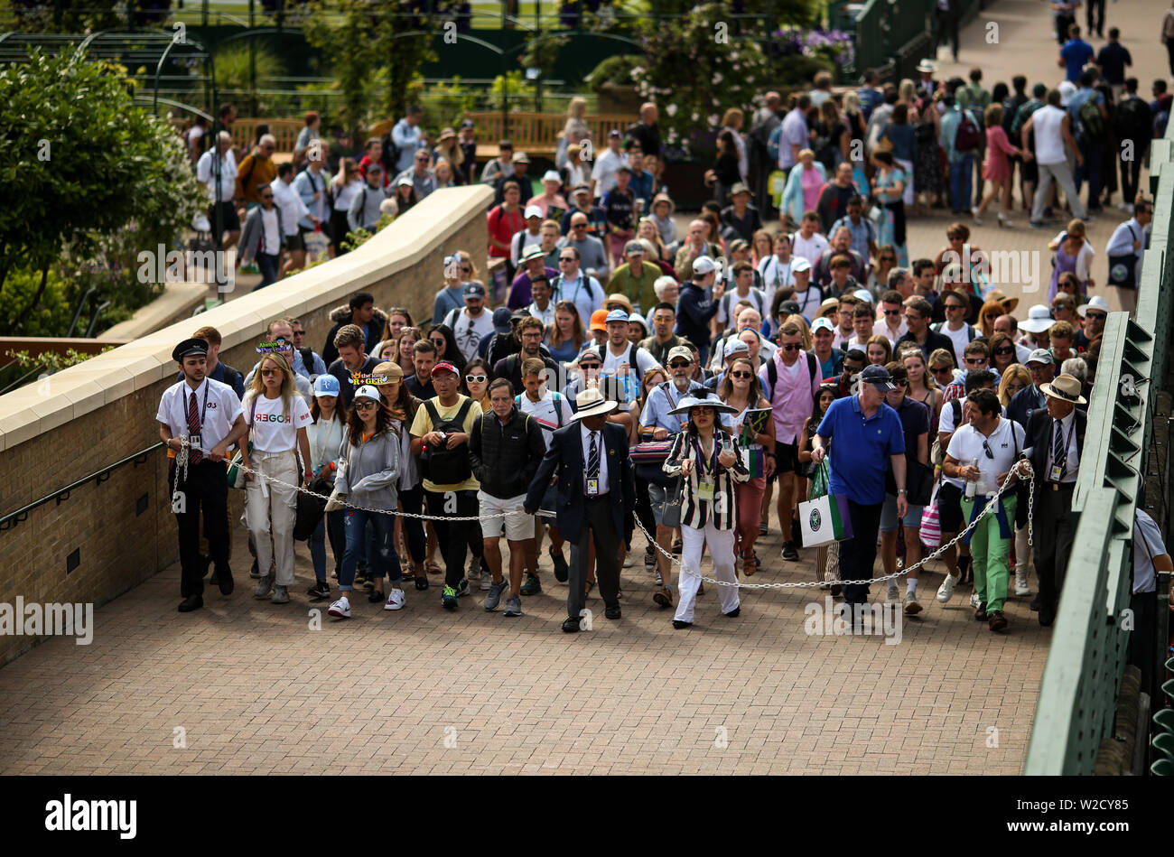 Spectators are led into the grounds at the start of day seven of the Wimbledon Championships at the All England Lawn Tennis and Croquet Club, Wimbledon. Stock Photo