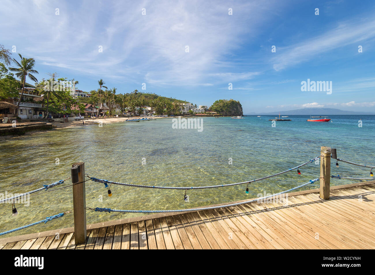 Sea, blue sky, palms and boats in White beach, Sabang, Puerto Galera, Philippines. Popular tourist and diving spot Stock Photo