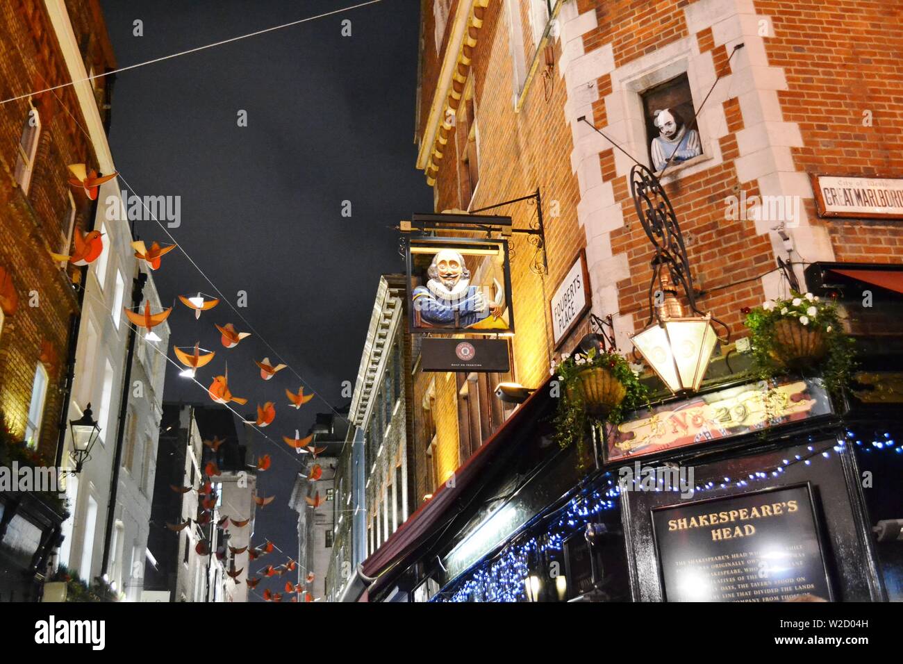 London/UK - November 28, 2013: Close-up view Shakespeare's head pub in the Carnaby street decorated for Christmas with red birds to feel happiness. Stock Photo