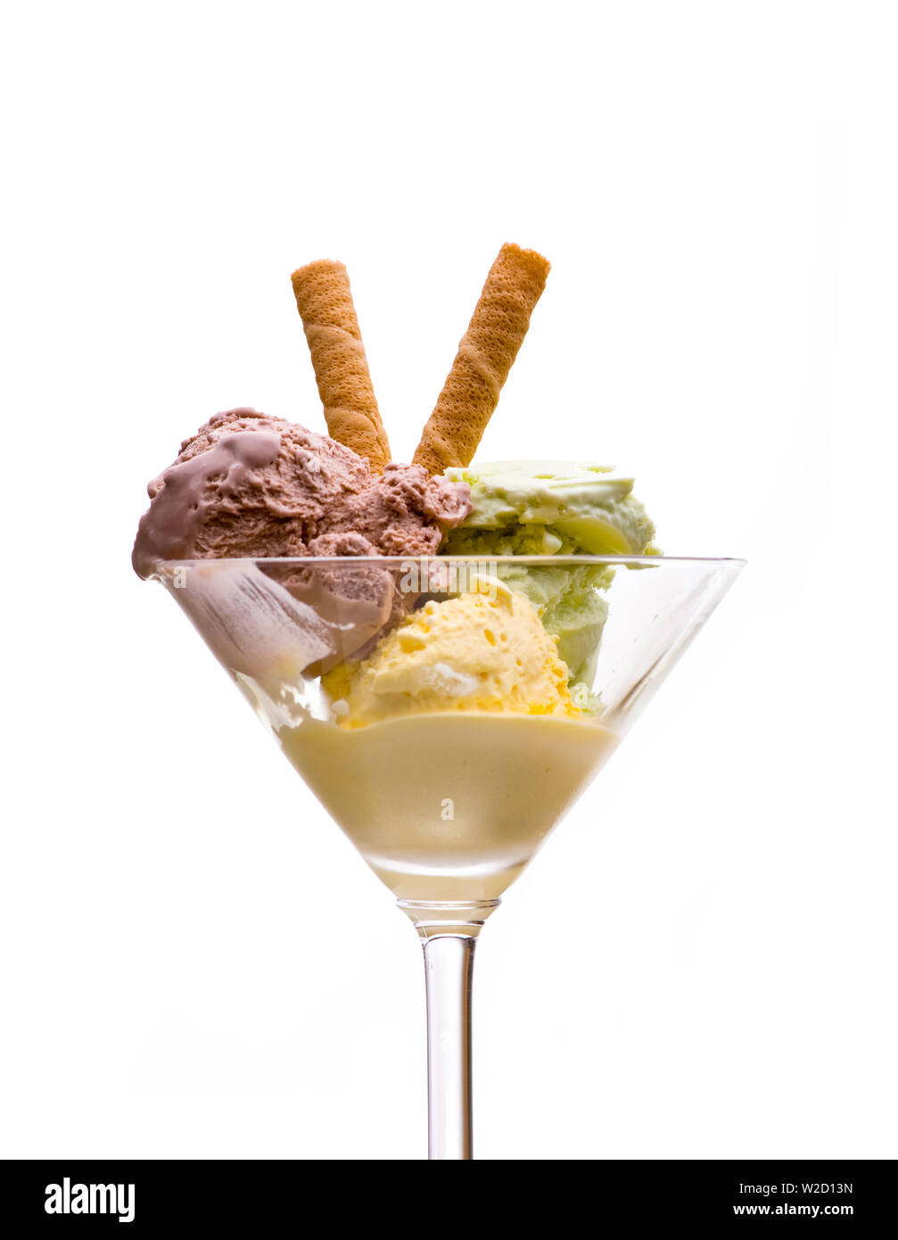 ice cream sundae: front view of ice cream sundae with yellow, green and brown ice cream with waffle in a martini glass on white background Stock Photo