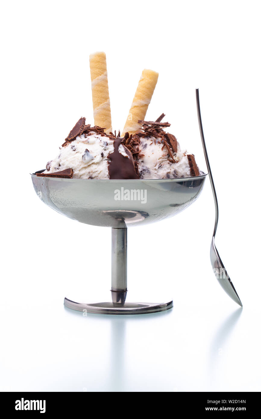 ice cream sundae: a stracciatella ice cream sundae in classical metal pot with spoon on white background Stock Photo