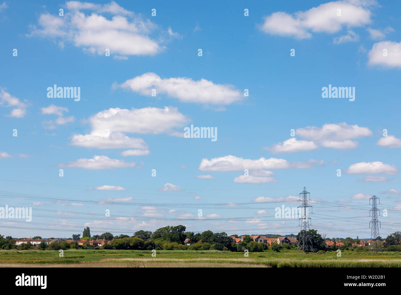 View over reed beds of the River Test estuary at Redbridge as it enters Southampton Water looking towards Totton with electricity pylons and lines Stock Photo