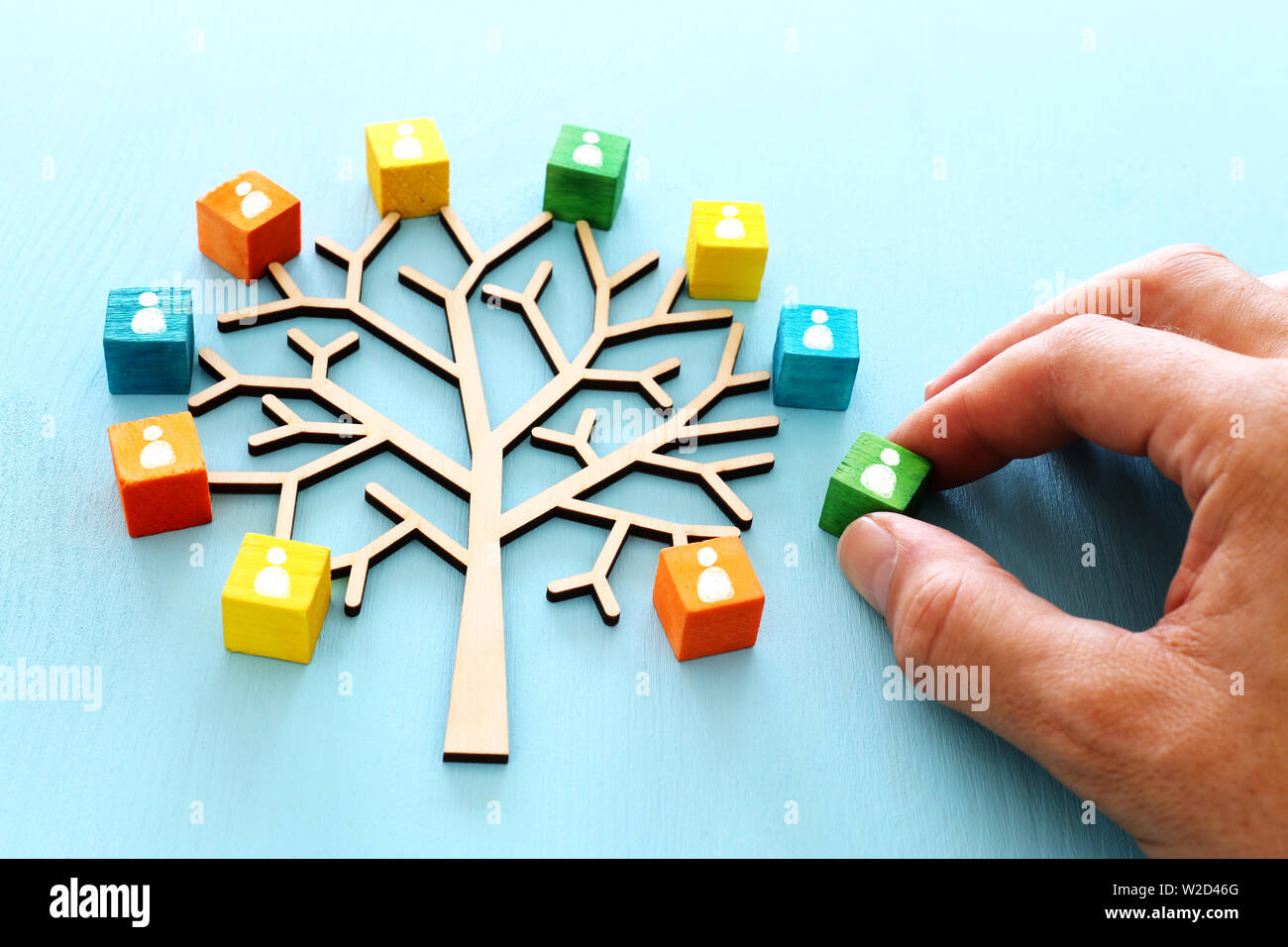 Business image of wooden tree with people icons over blue table, human ...