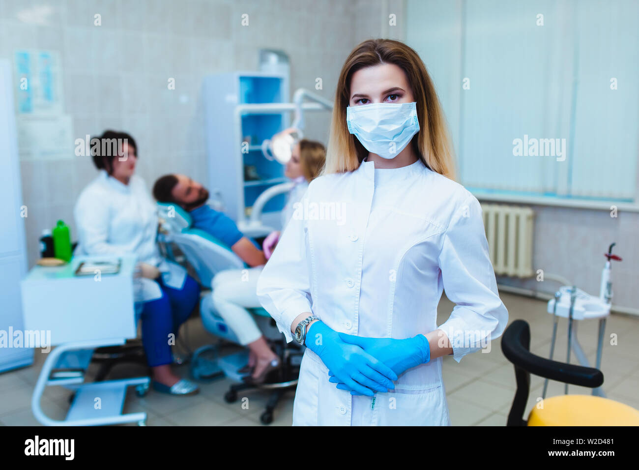 Dental clinic. Portrait of a professional dentist on the background of a  working team of doctors. Concept of medical education and medical insurance  Stock Photo - Alamy