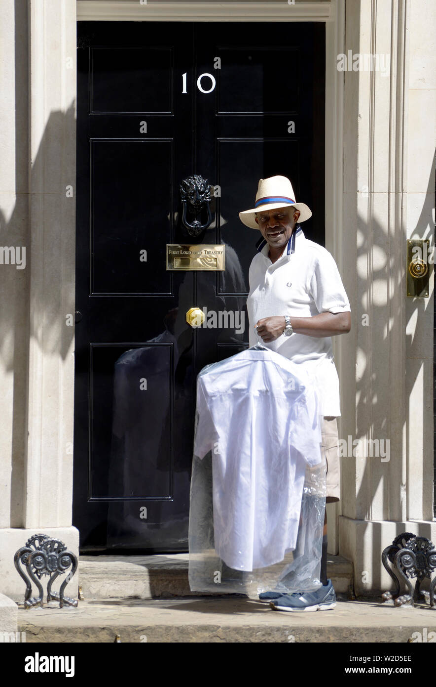 London, England, UK. Black wearing white delivering laundry / dry cleaning to 10 Downing Street Stock Photo