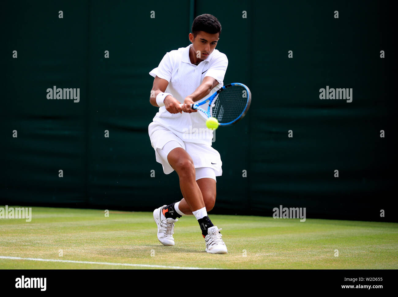 Nicolas Alvarez Varona in action against Felix Gill in the boys singles on day seven of the Wimbledon Championships at the All England Lawn Tennis and Croquet Club, Wimbledon Stock Photo -