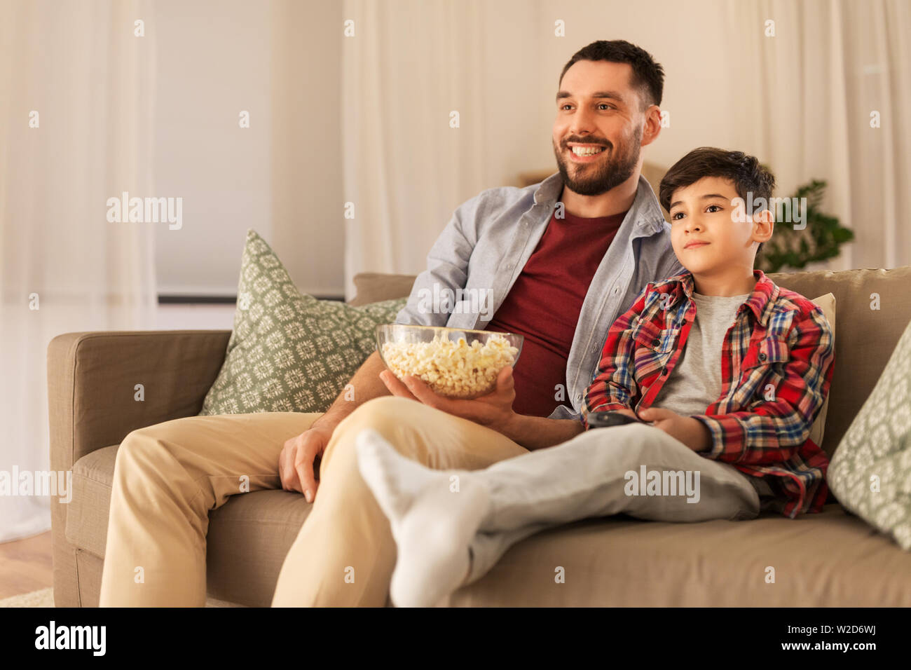 father-and-son-with-popcorn-watching-tv-at-home-stock-photo-alamy