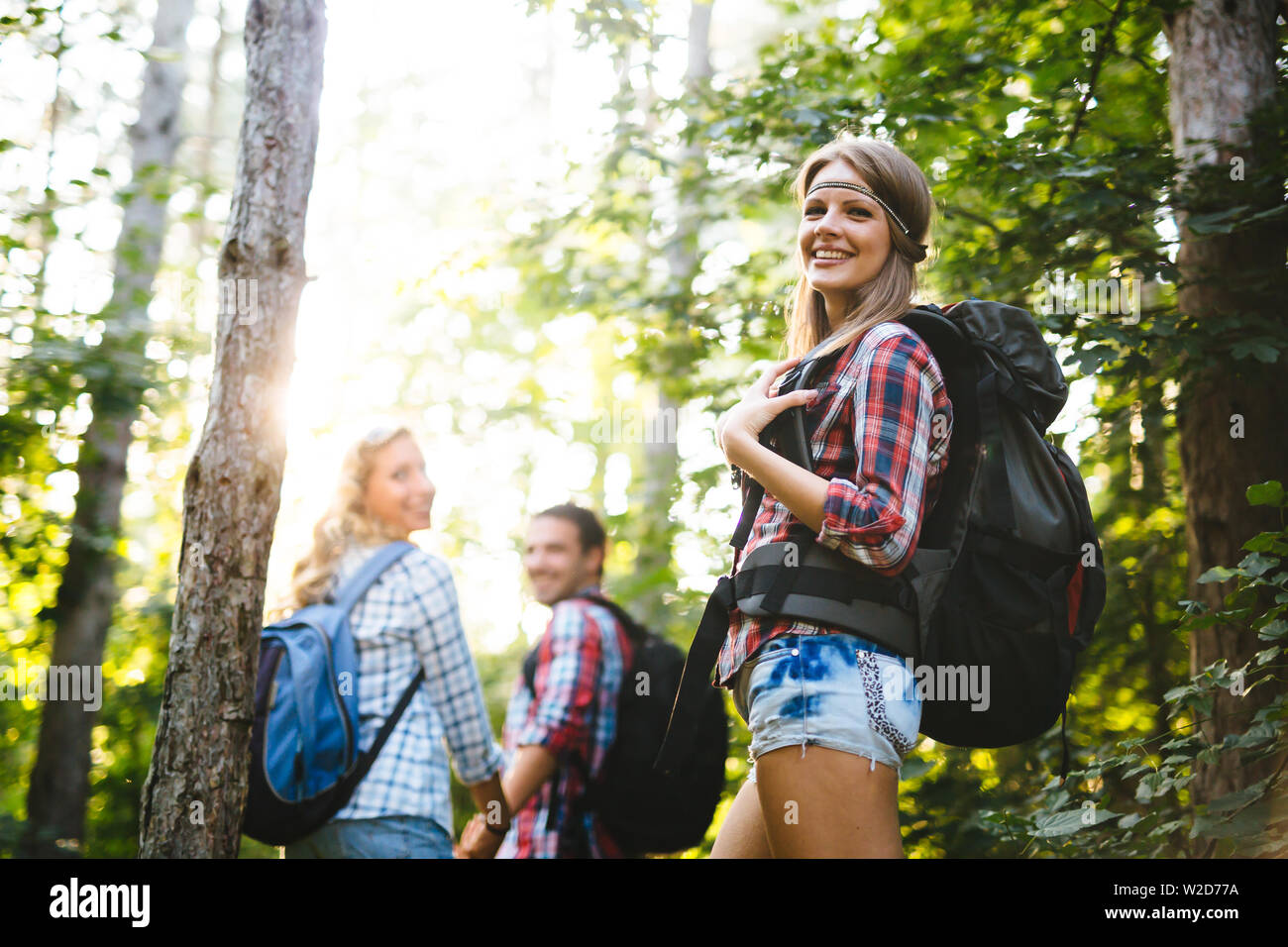 Beautiful woman and friends hiking in forest Stock Photo - Alamy
