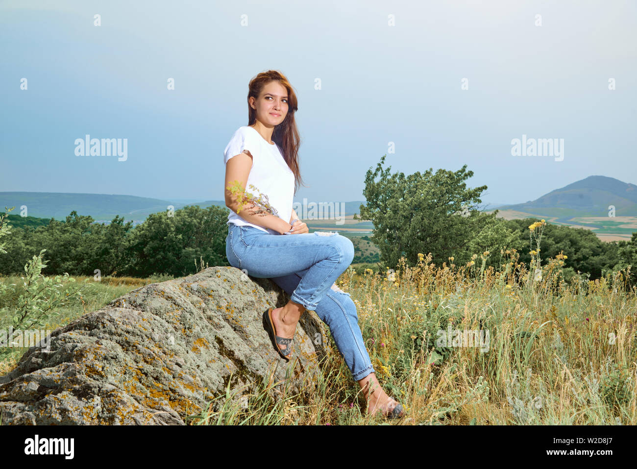 Passiv Forstad halt Girl in cowboy dress standing back on the top of Caucasus mountain with a  scenery view to sunset at green valley. Female travel nature concept Stock  Photo - Alamy