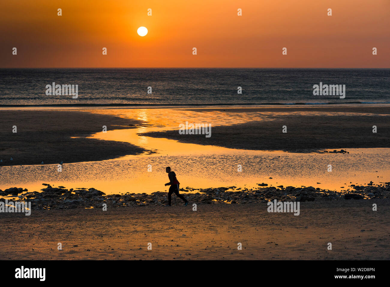 A beautiful intense sunset sets over Fistral Beach in Newquay in Cornwall. Stock Photo