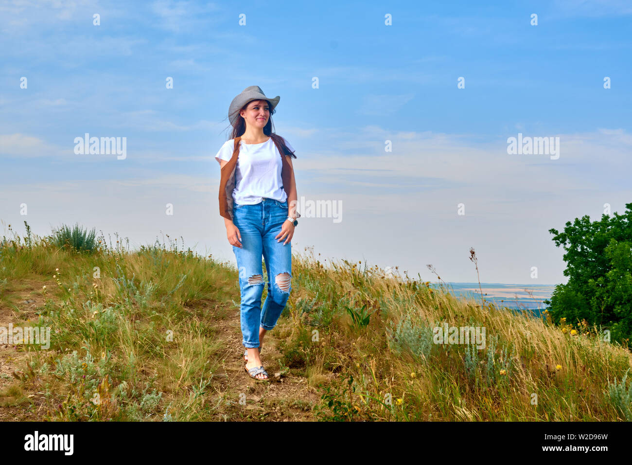 Passiv Forstad halt Girl in cowboy dress standing back on the top of Caucasus mountain with a  scenery view to sunset at green valley. Female travel nature concept Stock  Photo - Alamy