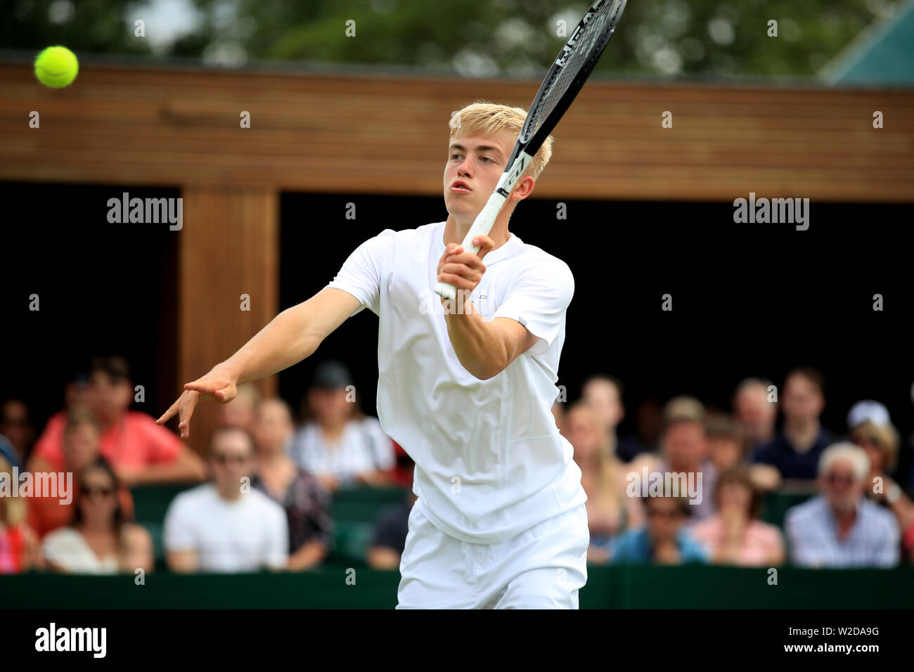 Felix Gill in action against Nicolas Alvarez Varona in the boys singles on day seven of the Wimbledon Championships at the All England Lawn tennis and Croquet Club, Wimbledon Stock Photo -