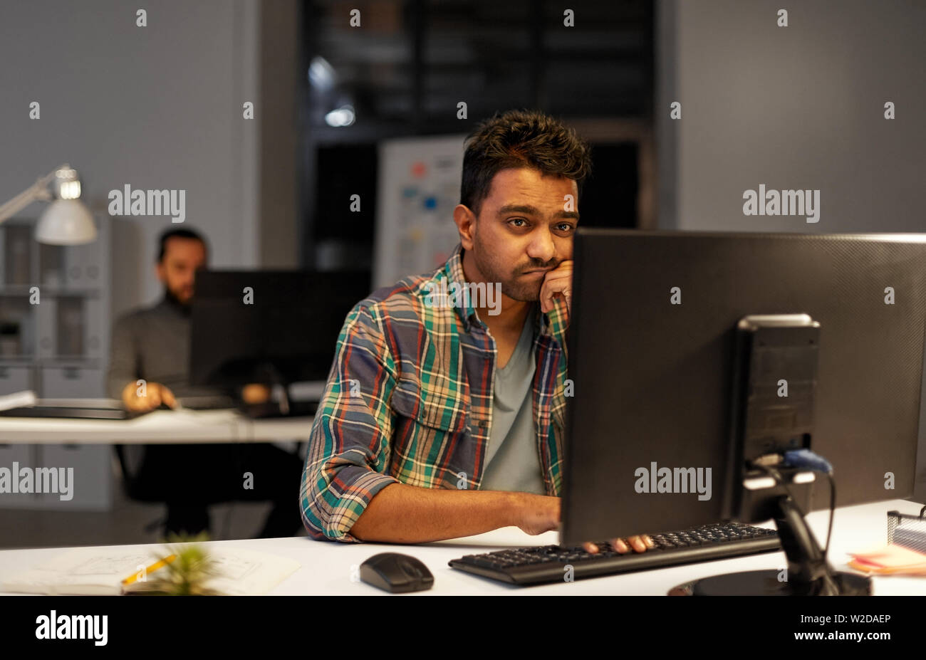 creative man with computer working at night office Stock Photo