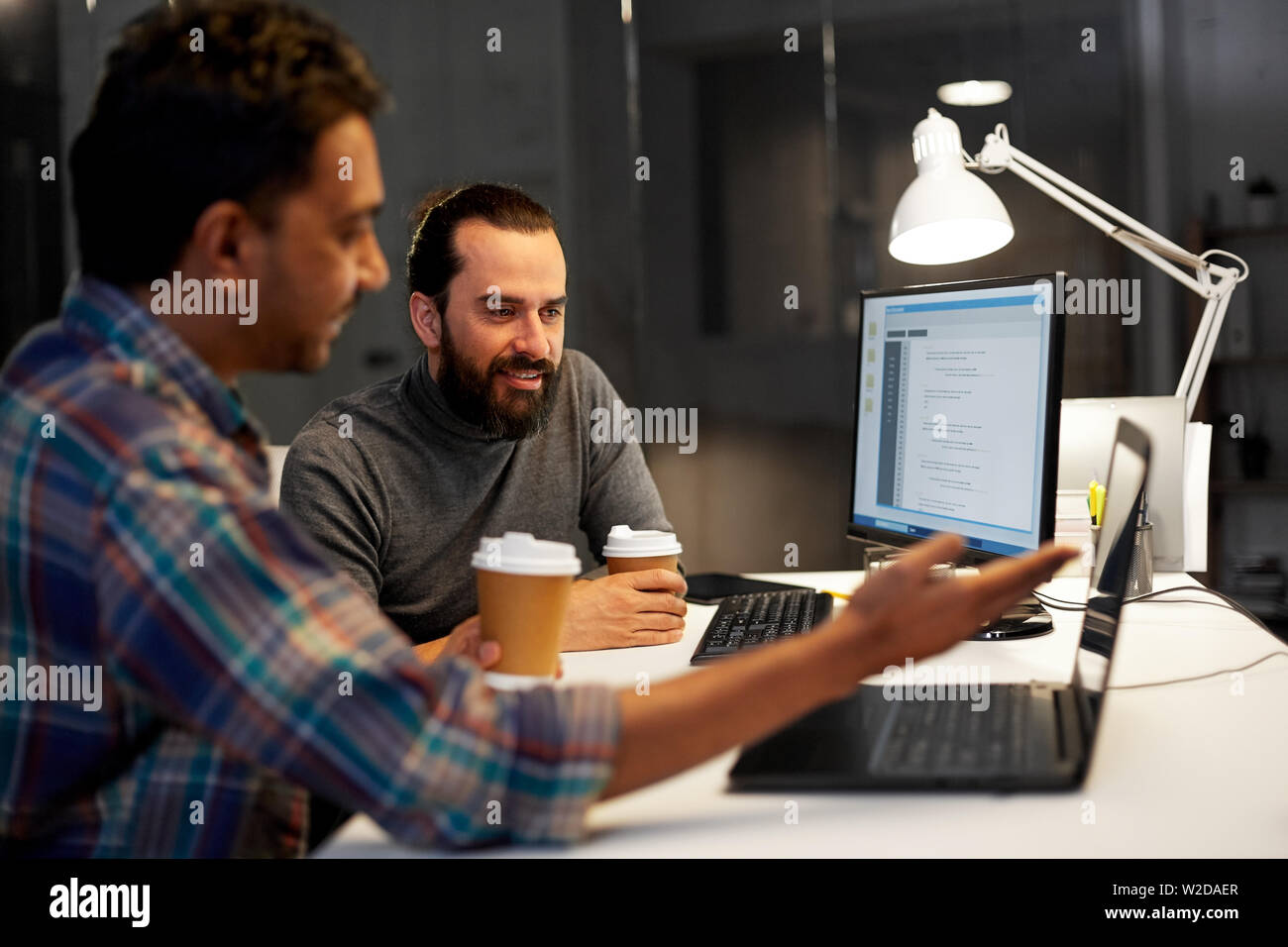 creative team drinking coffee at night office Stock Photo