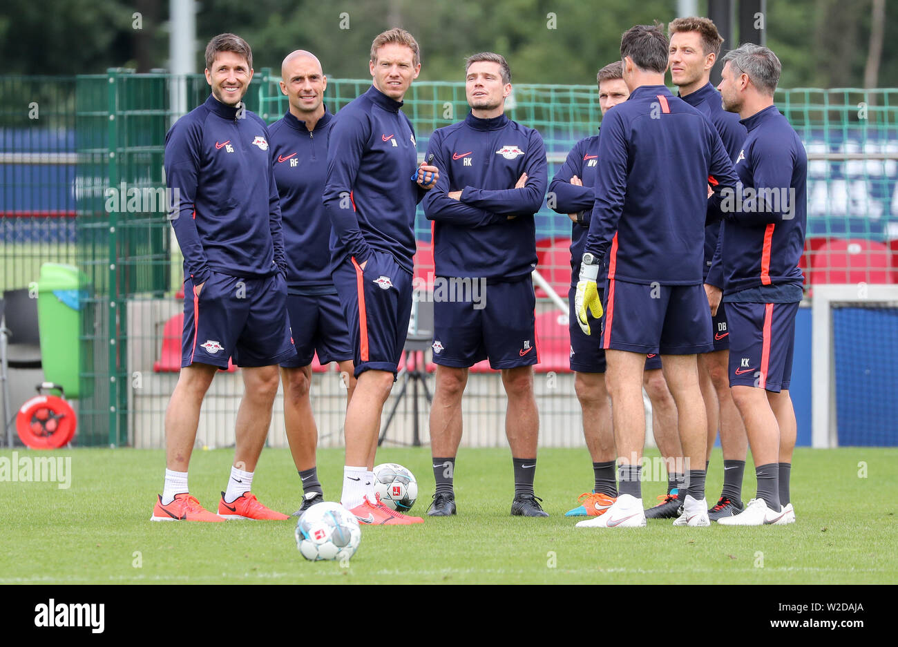 08 July 2019, Saxony, Leipzig: Soccer: Bundesliga, RB Leipzig. The new coach Julian Nagelsmann (3rd from left) and his trainer team Benjamin Glück, video analyst (l-r), Ruwen Faller, athletics coach, Robert Klauss, co-trainer, Moritz Volz, co-trainer, Daniel Behlau, athletics coach, Kai Kraft, athletics coach and Frederik Gössling, goalkeeper coach, are on the pitch after the first training session. Photo: Jan Woitas/dpa-Zentralbild/dpa - IMPORTANT NOTE: In accordance with the requirements of the DFL Deutsche Fußball Liga or the DFB Deutscher Fußball-Bund, it is prohibited to use or have used Stock Photo