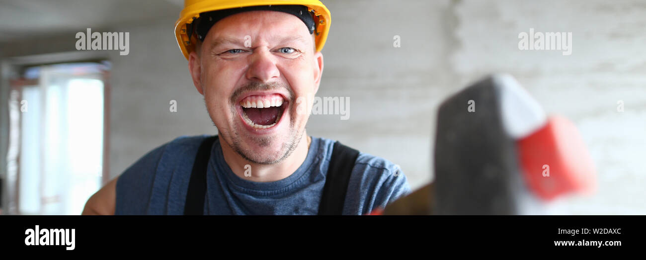 Angry builder holding sledgehammer and Stock Photo