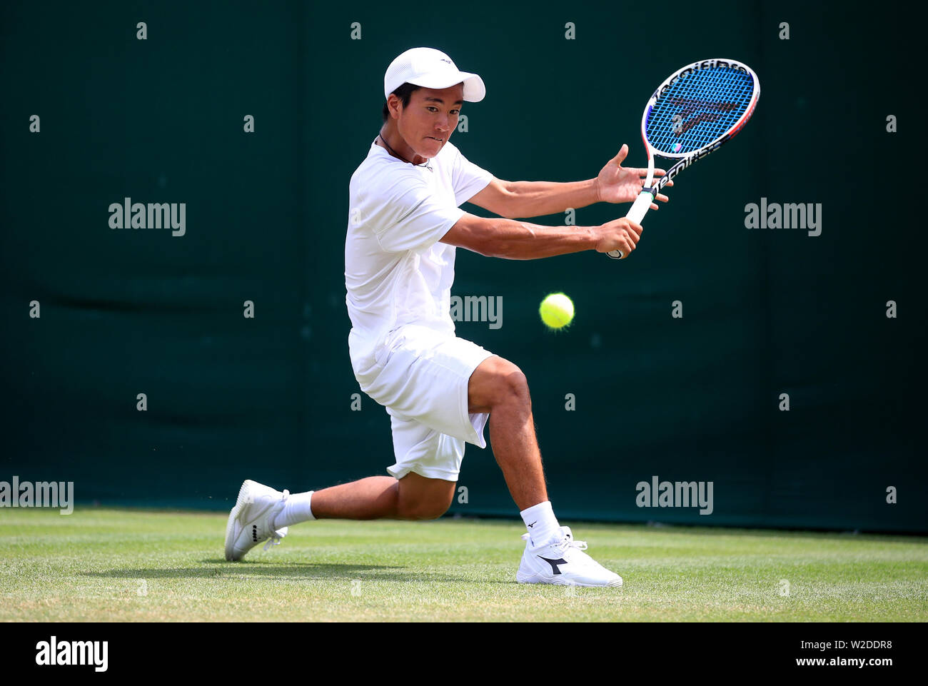 Ryoma Matsushita in action against Blu Baker in the boys singles on day seven of the Wimbledon Championships at the All England Lawn Tennis and Croquet Club, Wimbledon. Stock Photo