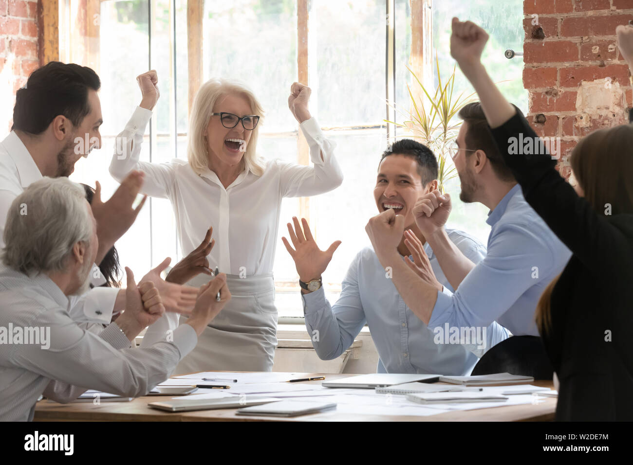 Overjoyed happy corporate business team people scream celebrate triumph Stock Photo