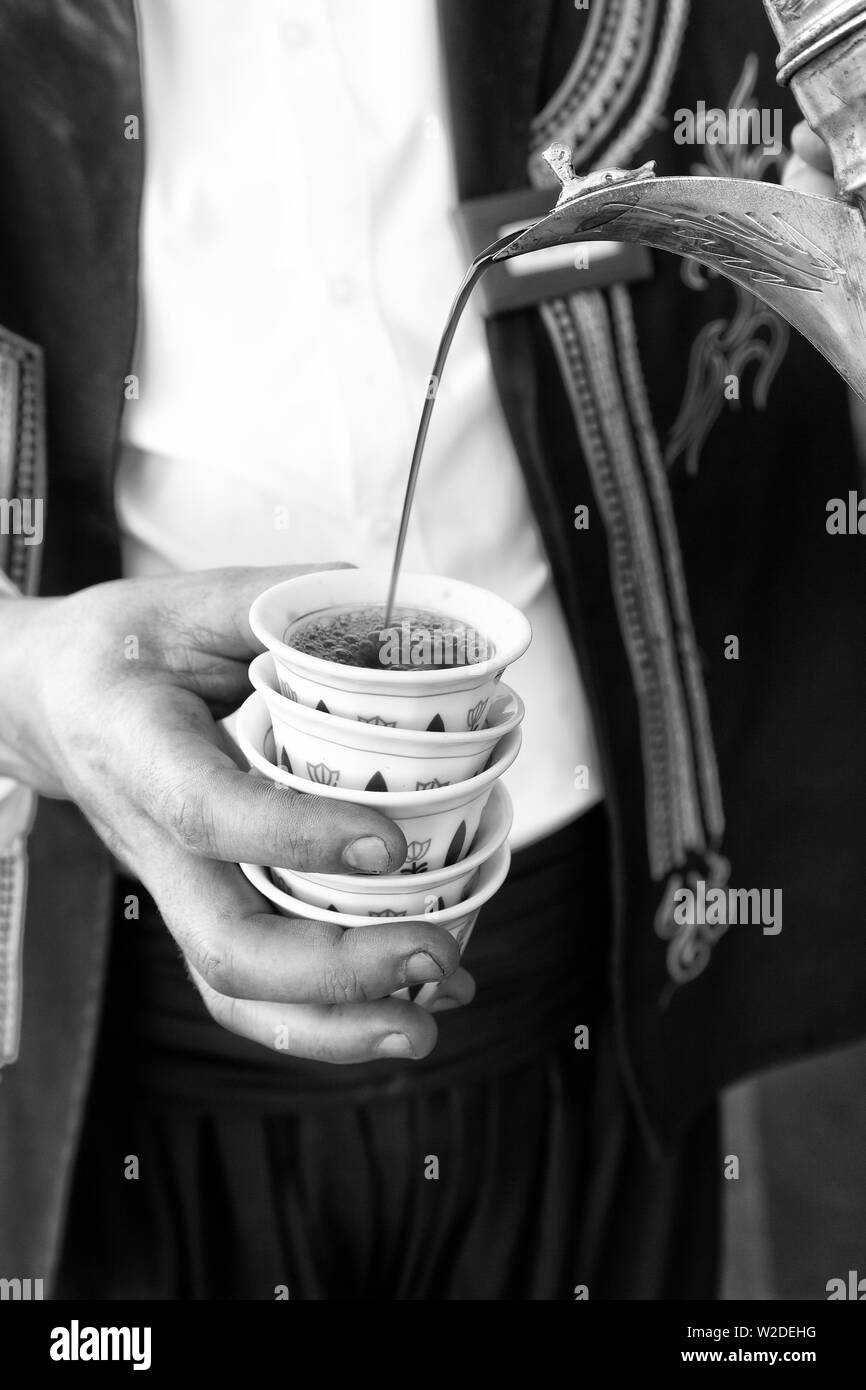 person pouring coffee from turka into a coffee cup Stock Photo - Alamy