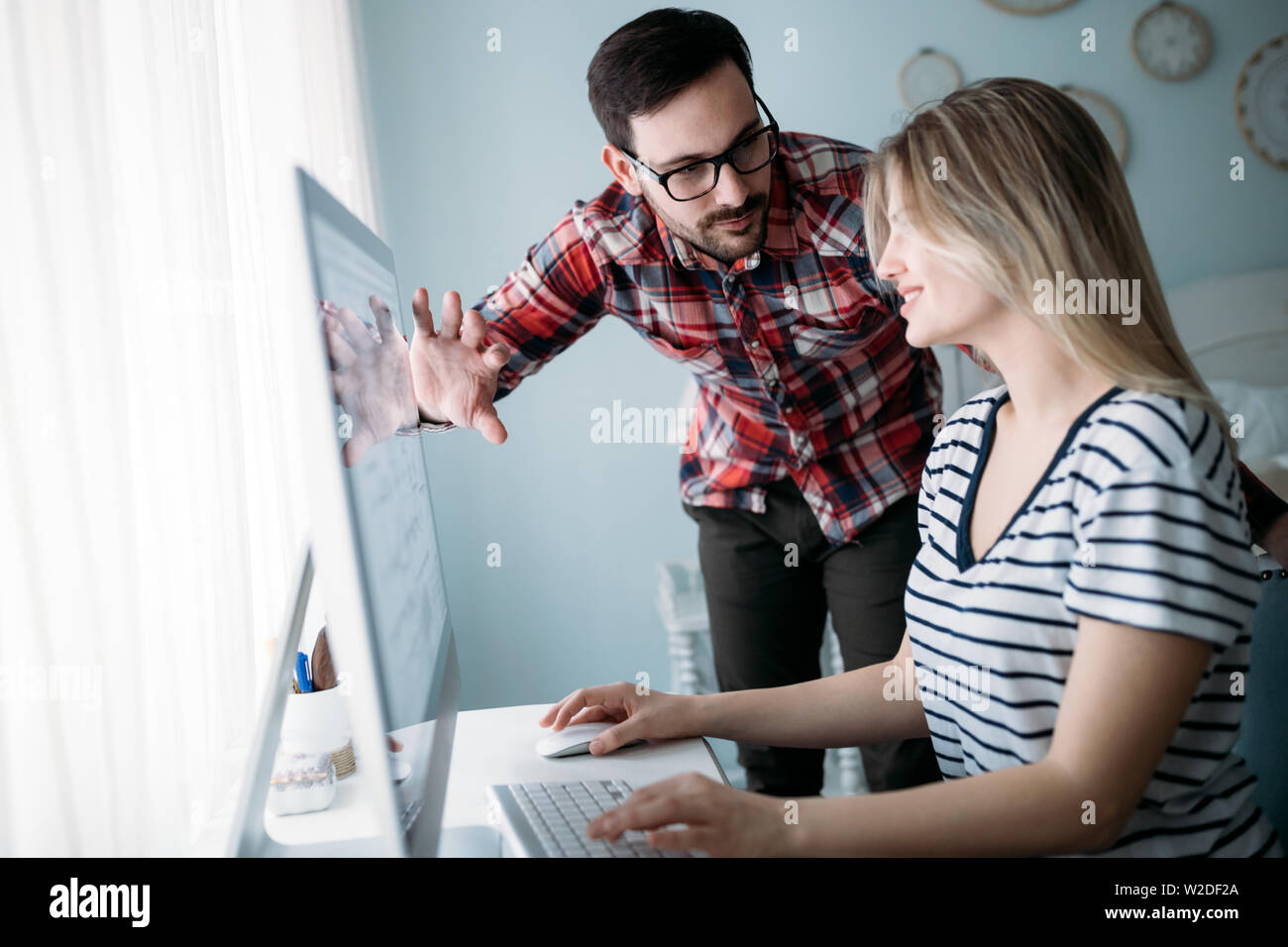 Young attractive designers working on project together Stock Photo