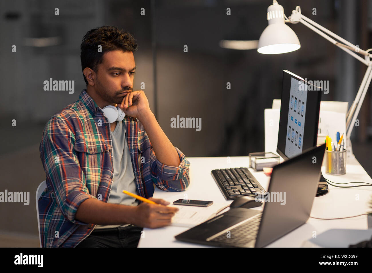 creative man with laptop working at night office Stock Photo