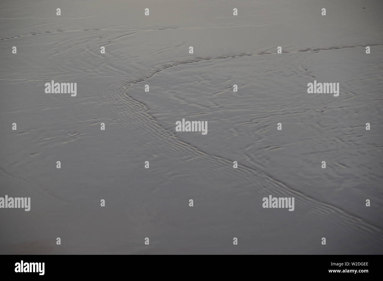 Capillary Waves / Ripples Flowing Over Wet Beach Sand. Natural Abstract ...