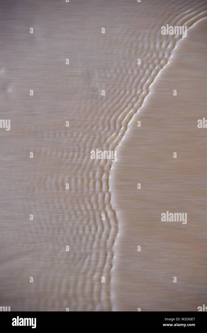 Capillary Waves / Ripples Flowing Over Wet Beach Sand. Natural Abstract ...