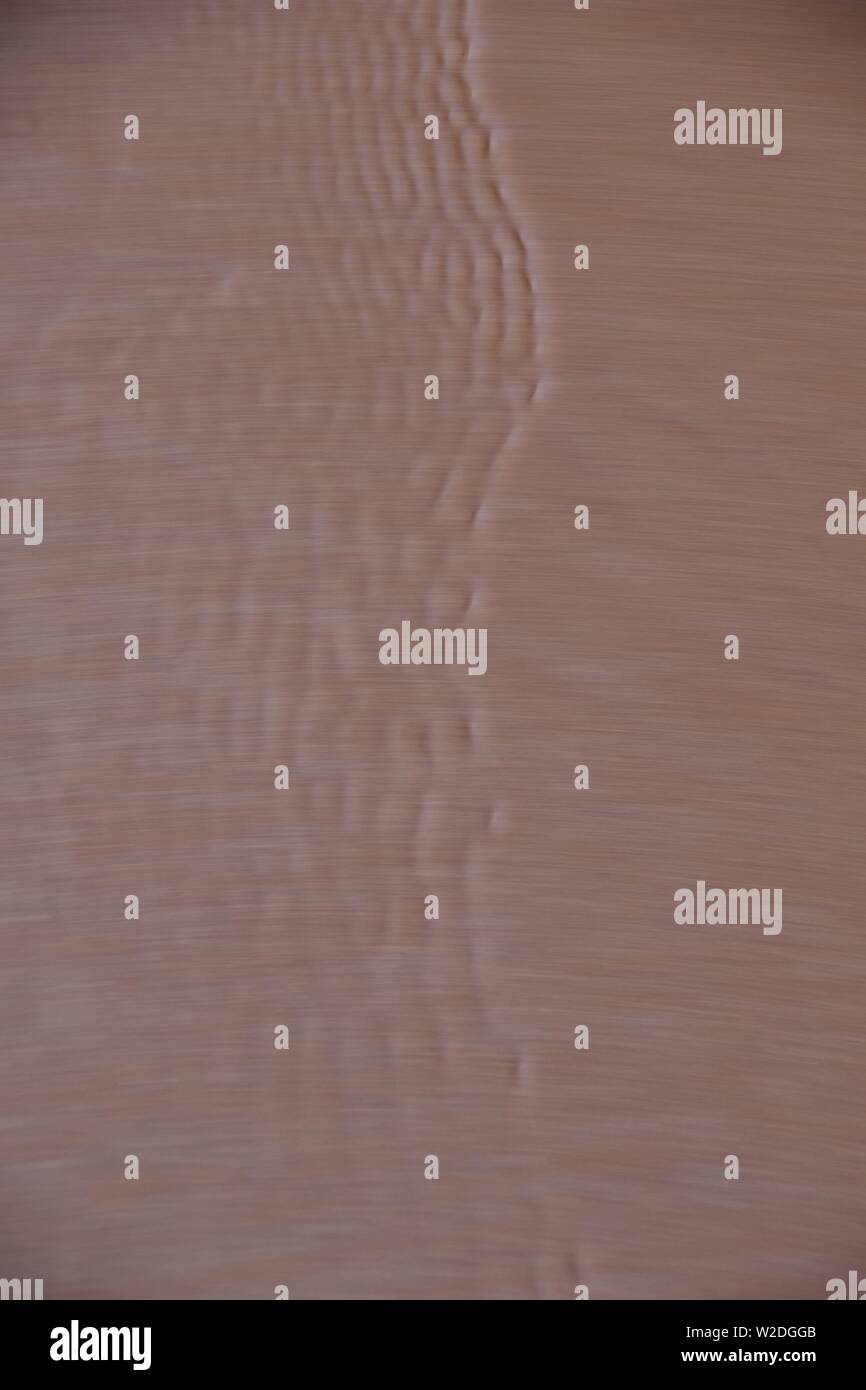 Capillary Waves / Ripples Flowing Over Wet Beach Sand. Natural Abstract