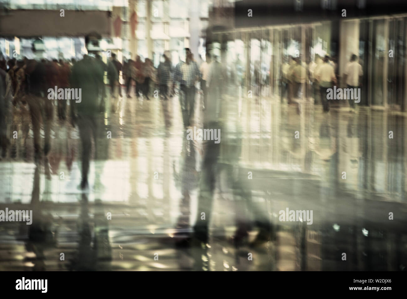 crowd of people walking shot through glass distorted glass Stock Photo