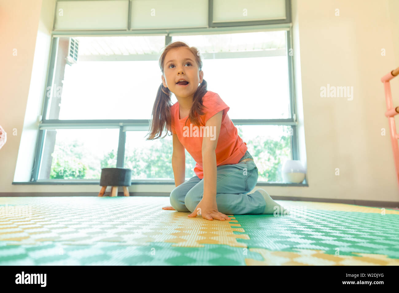 Cute pleasant girl sitting on the floor Stock Photo - Alamy