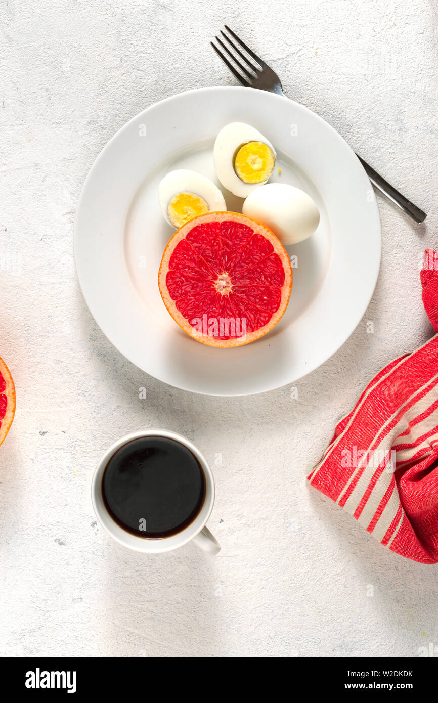 Boiled egg diet concept. Eggs with grapefruit and cup of black coffee
