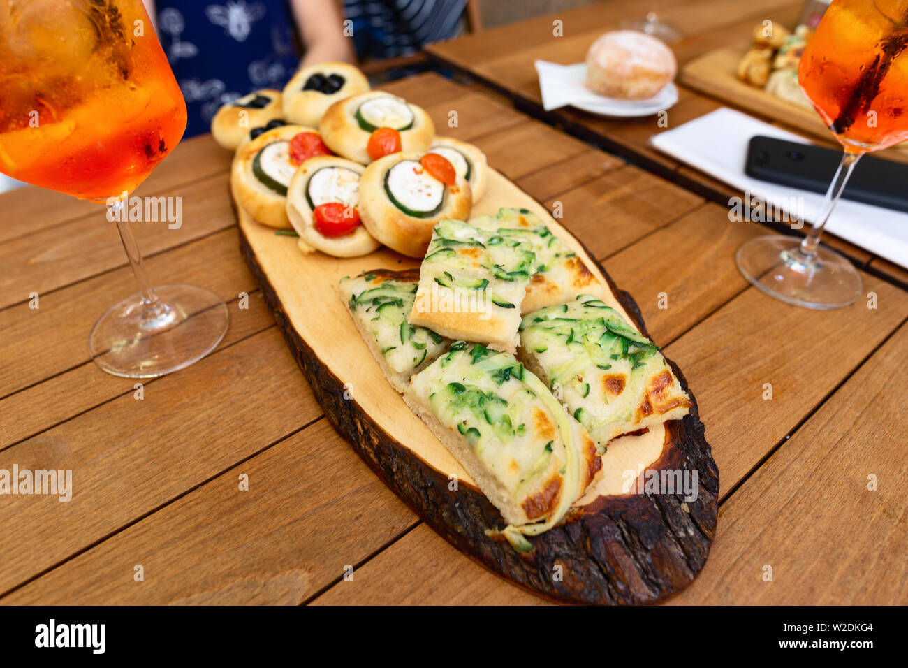Various snacks with aperol spritz cocktail on wooden table in a cafe ...