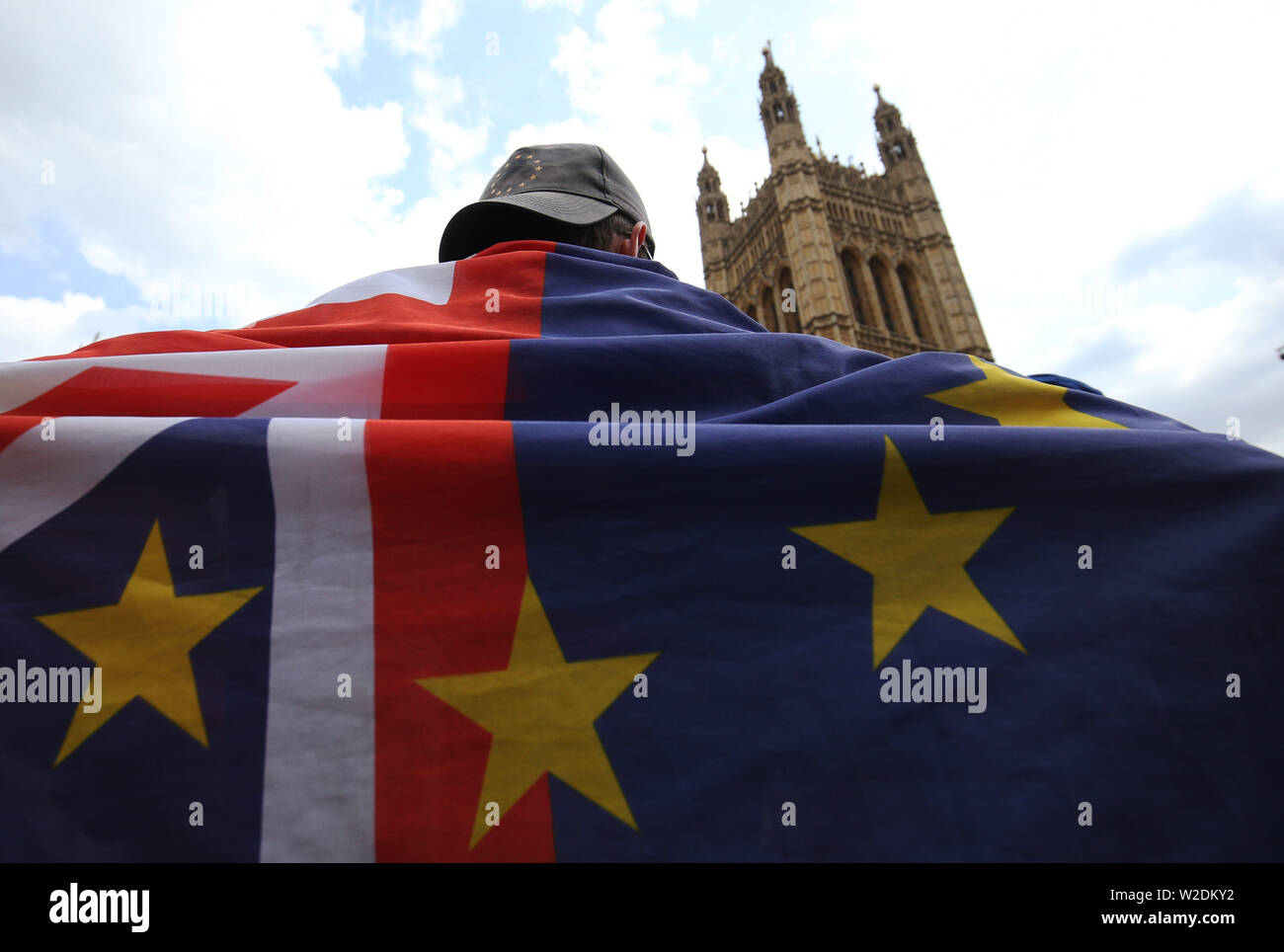 A pro EU activist wears flags of the European Union and Great Britain together across his back while standing near the Palace of Westminster. Stock Photo